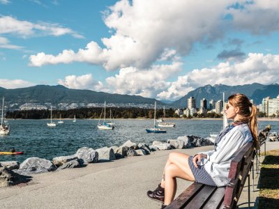 Girl Sitting on a Bench at Kitsilano Beach in Vancouver, Canada