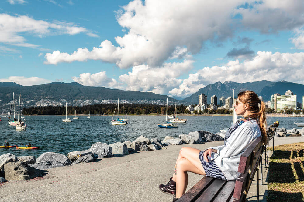 Girl Sitting on a Bench at Kitsilano Beach in Vancouver, Canada