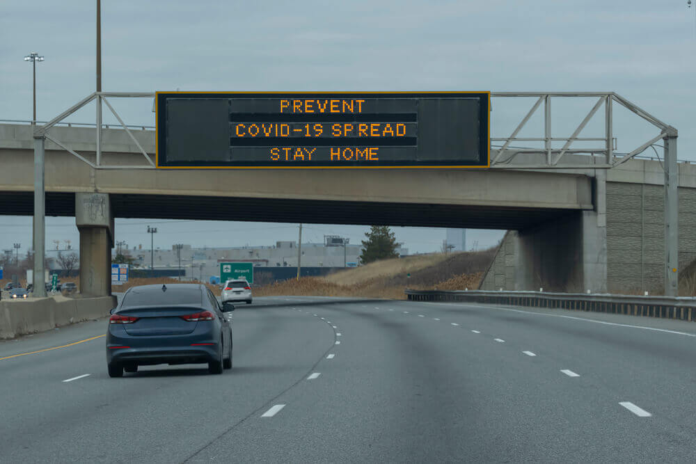 Sign prevent covid-19 spread, stay home on a scoreboard over highway during corona virus pandemic outbreak lockdown